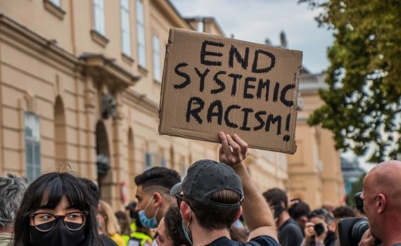 Manifestación con pancartas de Fin del racismo endémico