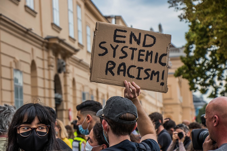 Manifestación con pancartas de Fin del racismo endémico