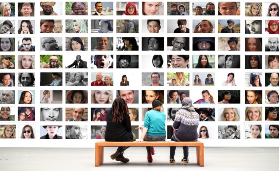 tres personas ante un mural hecho de fotos humanas