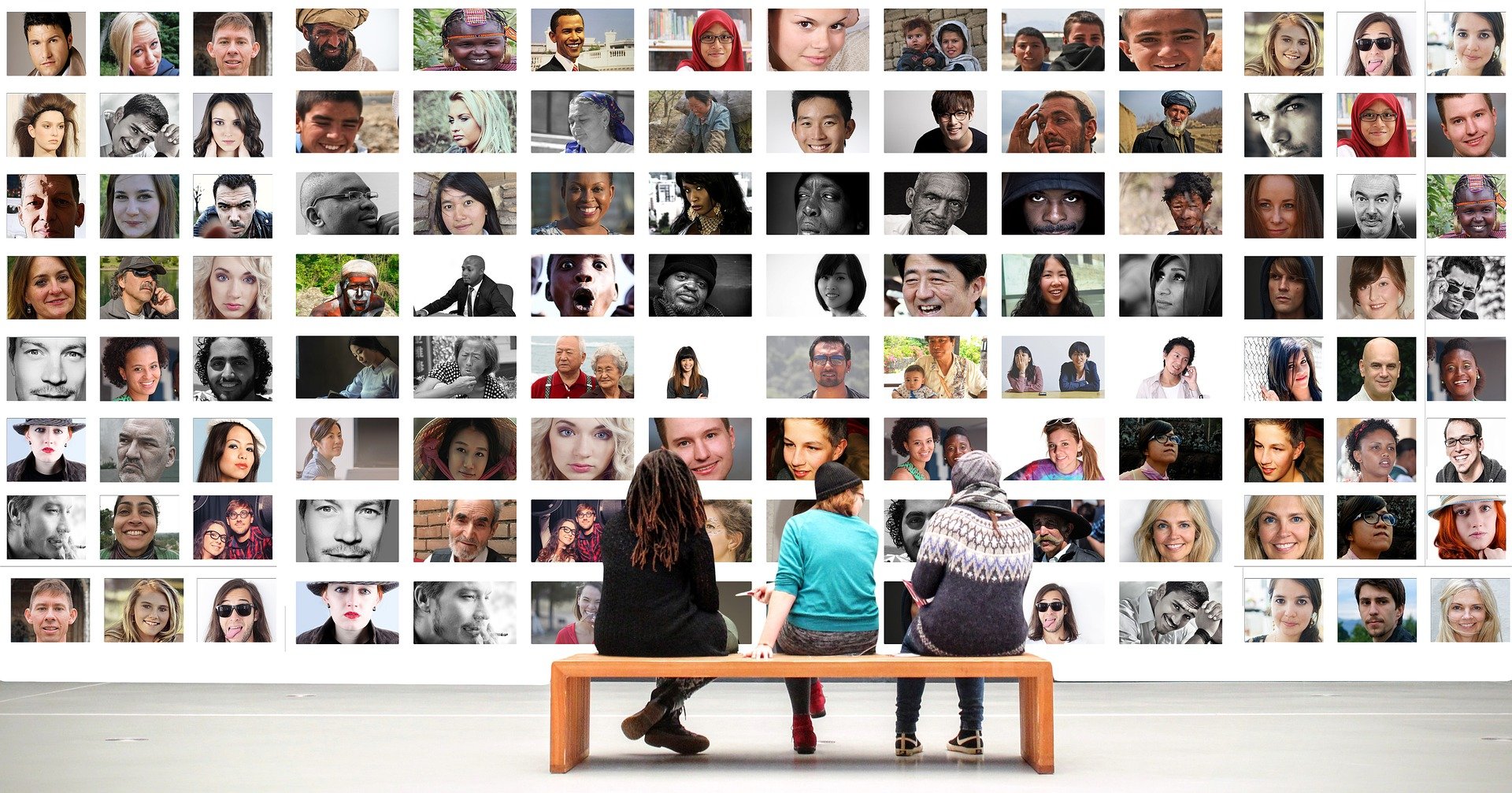 tres personas ante un mural hecho de fotos humanas