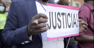 Una mujer sostiene una pancarta con la palabra Justicia